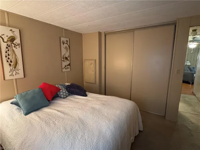 Carpeted bedroom featuring a closet and a textured ceiling