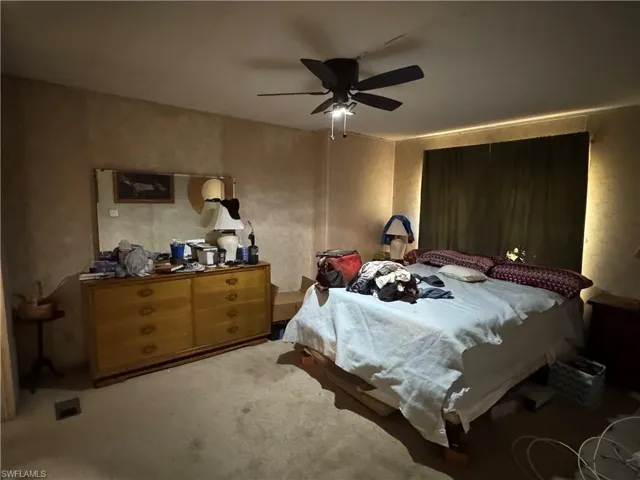 Bedroom with a ceiling fan and light carpet
