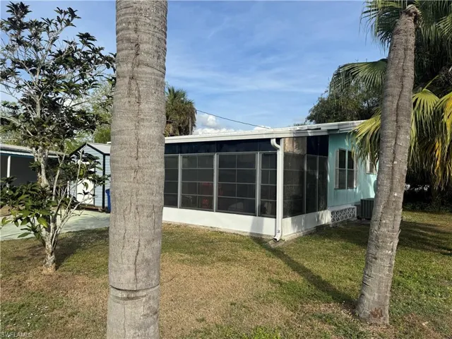 View of property exterior with a yard and a sunroom