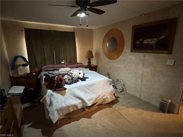 Carpeted bedroom with a ceiling fan
