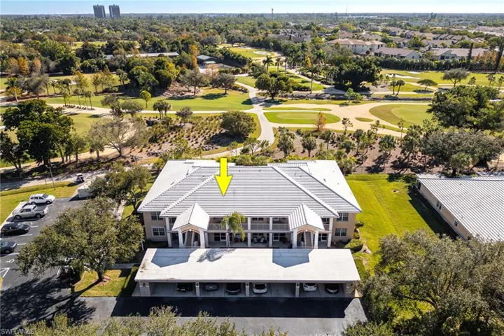 Aerial view - front of building, extra parking on the side and car port structures.