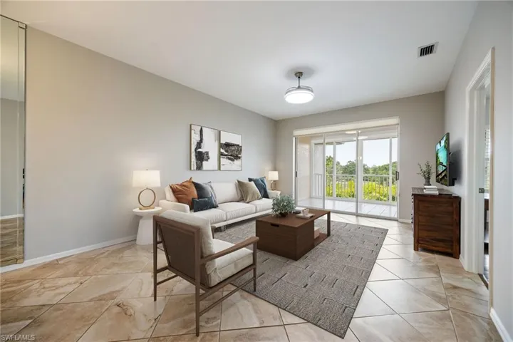 Living Room w/ open floor plan. Gorgeous views of golf course & mature florida landscaping. Door to right opens into primary bedroom. Recently painted w/ neutral palette. Note: virtually staged photo