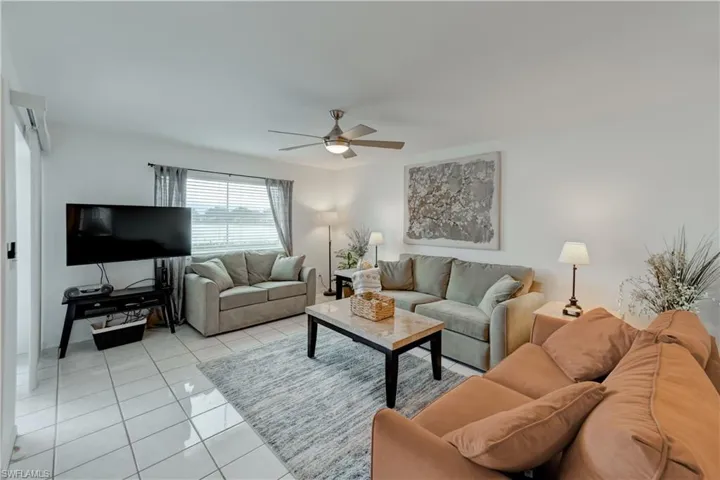 Family room with 3 sofas  (one is a sleeper) & TV. View of lake.