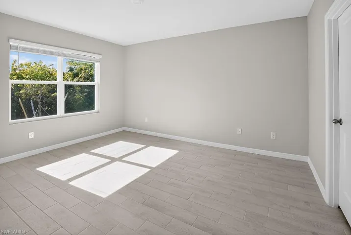 Unfurnished room featuring wood finish floors and baseboards
