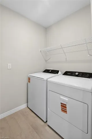 Laundry area featuring washing machine and clothes dryer and light wood-style floors
