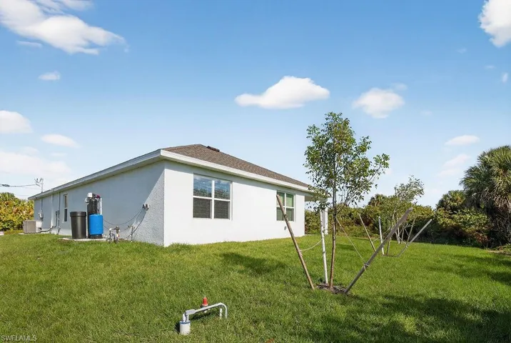 View of property exterior featuring stucco siding and a yard