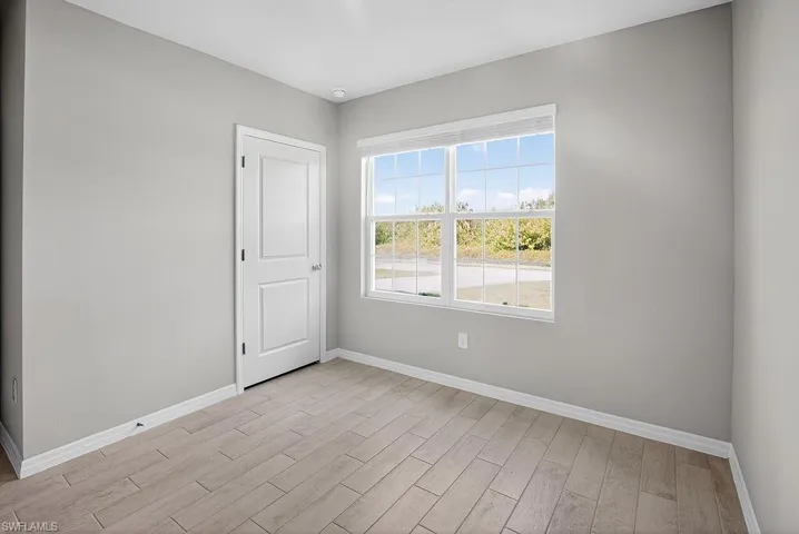 Unfurnished room with baseboards and wood finish floors