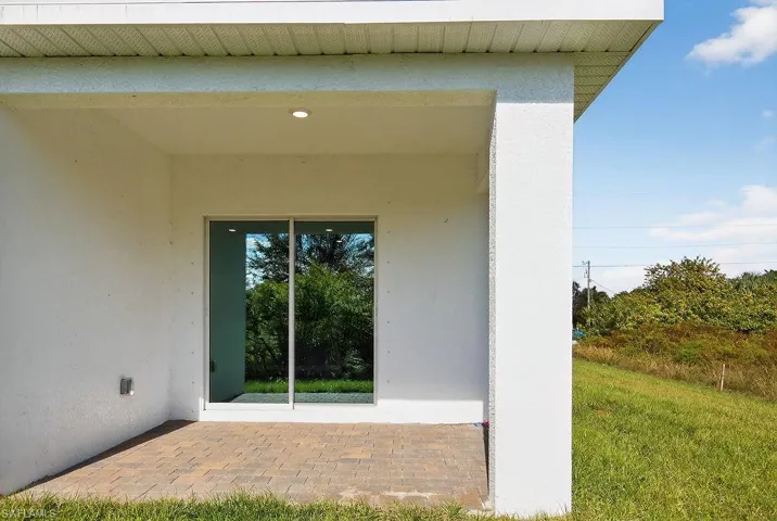 Doorway to property with a patio and stucco siding