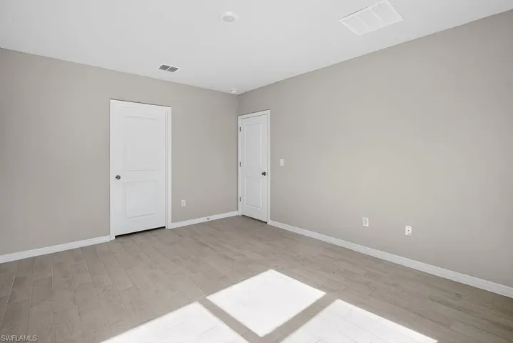 Unfurnished bedroom with light wood-style flooring and baseboards
