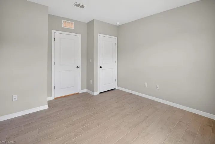 Unfurnished bedroom with baseboards and light wood-style floors
