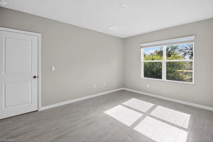Spare room with baseboards and wood finish floors