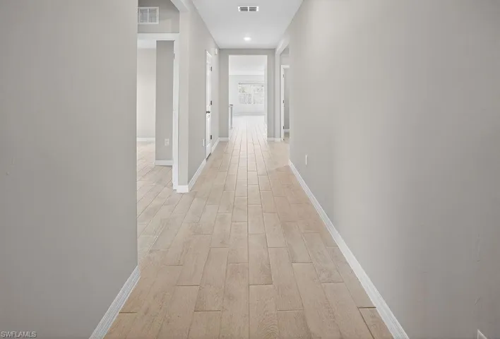 Hall featuring light wood finished floors and recessed lighting