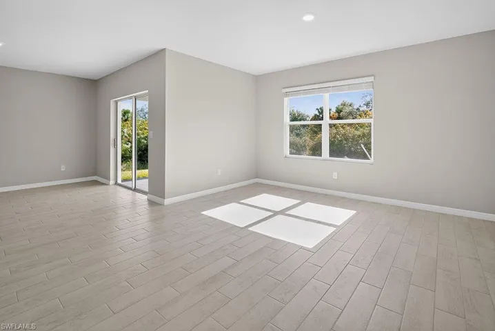 Spare room with wood tiled floors, healthy amount of natural light, and recessed lighting