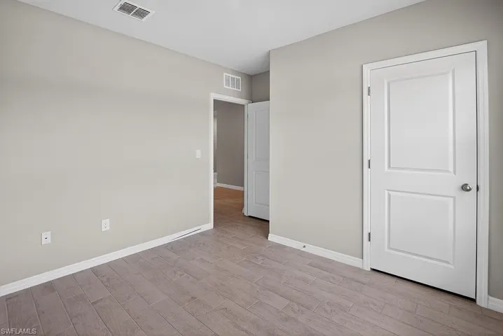 Unfurnished bedroom with baseboards and light wood finished floors