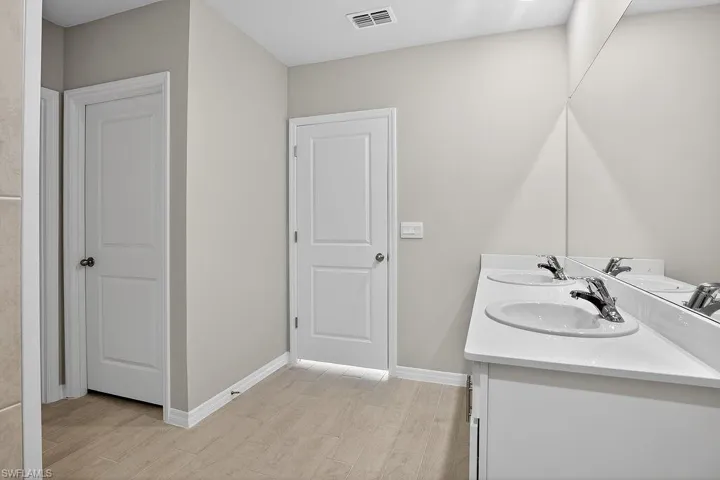 Bathroom featuring double vanity and light wood-style floors