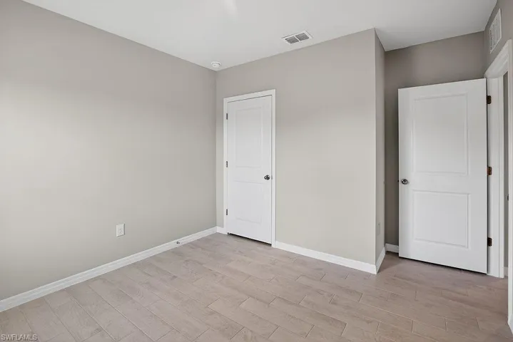 Unfurnished bedroom with baseboards and light wood-type flooring