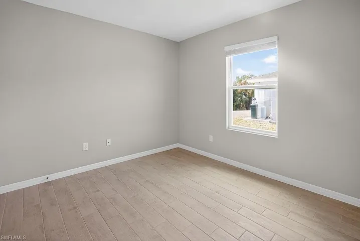 Empty room with baseboards and light wood-style floors