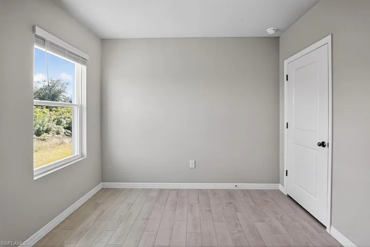 Unfurnished room featuring light wood-type flooring and baseboards