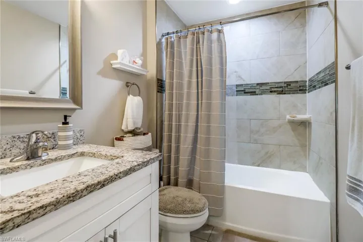 Full bathroom featuring vanity, tile patterned flooring, toilet, and shower / bath combination with curtain