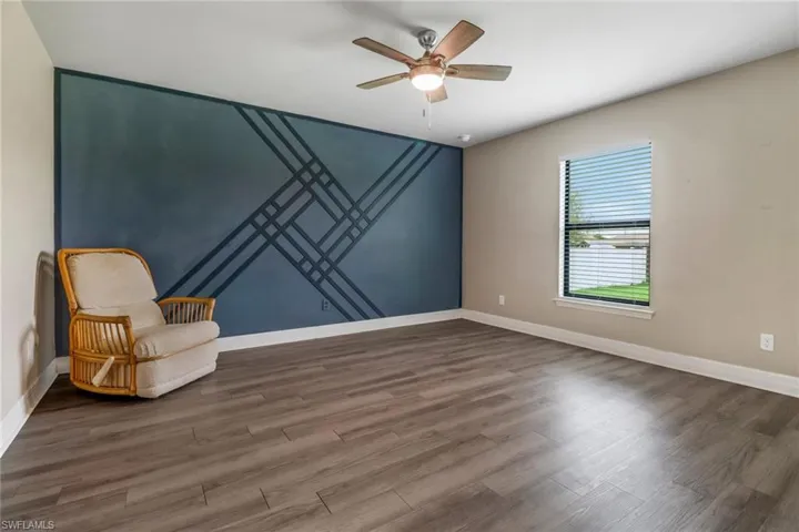 Unfurnished room featuring dark hardwood / wood-style flooring and ceiling fan