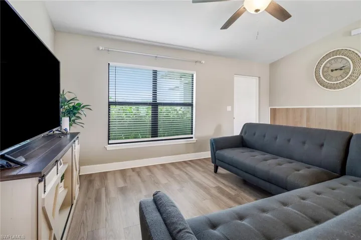 Living room featuring ceiling fan, lofted ceiling, light wood-type flooring, and plenty of natural light