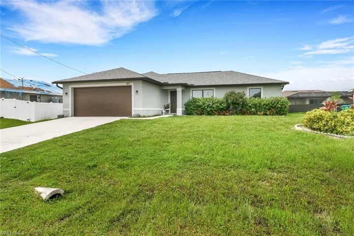 Ranch-style house featuring a garage and a front lawn