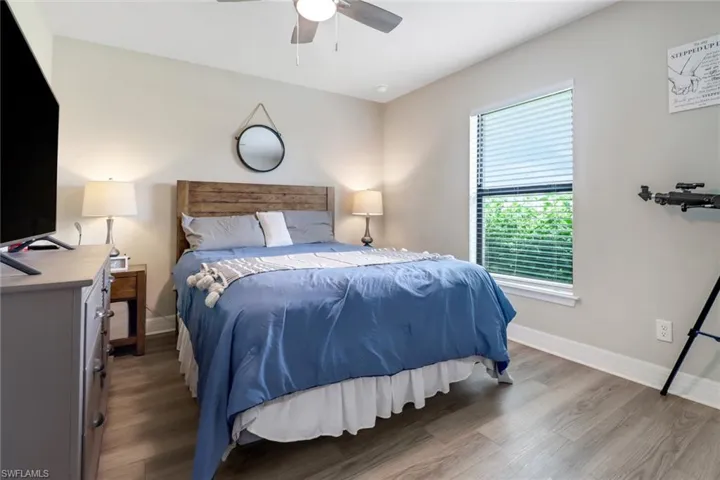 Bedroom featuring multiple windows, hardwood / wood-style flooring, and ceiling fan