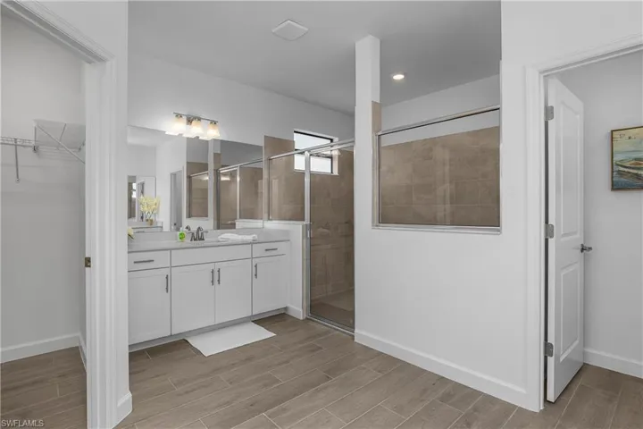 Primary bath features TWO walk-in closets, dual sinks and frameless walk-in shower.