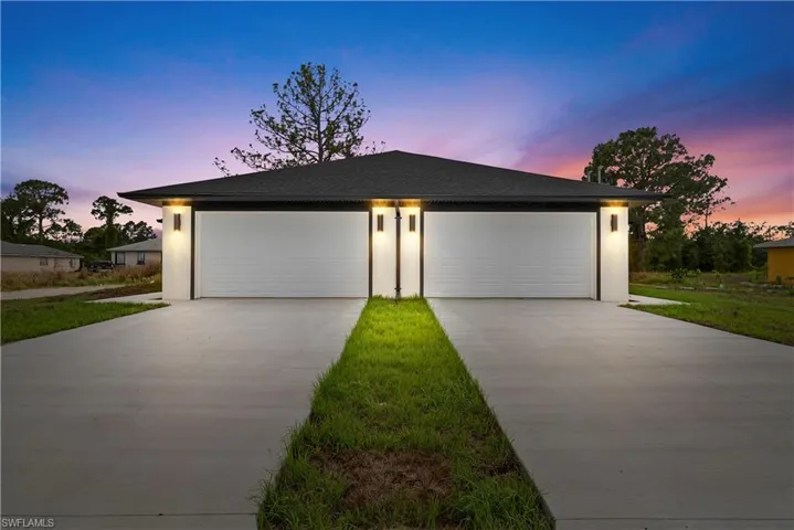 View of front of house featuring a garage, concrete driveway, stucco siding, and a shingled roof