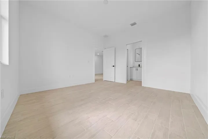 Unfurnished bedroom with wood tiled floors and ensuite bathroom