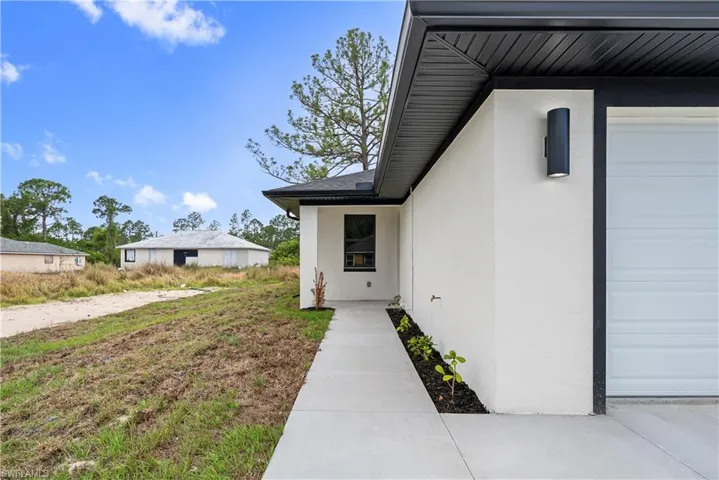 Entrance to property with stucco siding and a garage