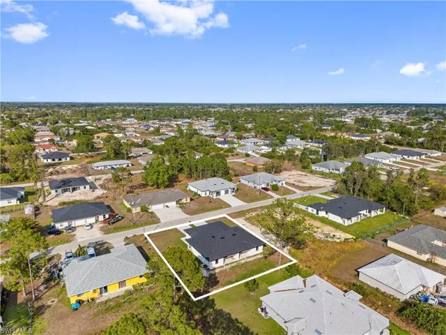Aerial view of property and surrounding area with nearby suburban area