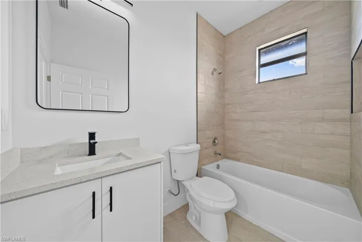 Bathroom with vanity, shower / washtub combination, and light wood finished floors