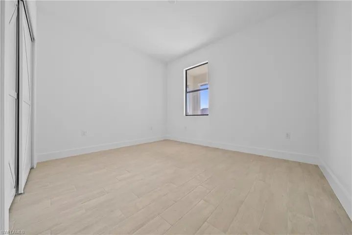 Unfurnished bedroom with light wood-style floors and baseboards