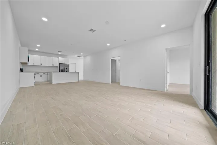 Unfurnished living room featuring recessed lighting and wood tiled floors