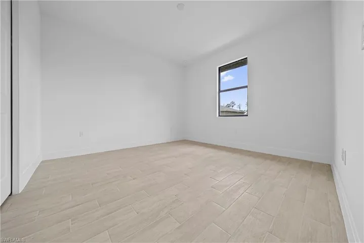 Unfurnished room with wood finish floors and baseboards