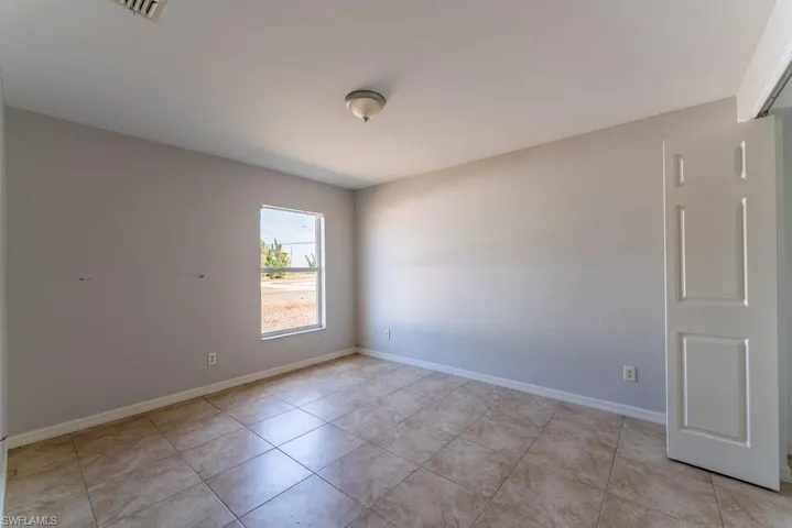 Unfurnished room with baseboards and light tile patterned floors