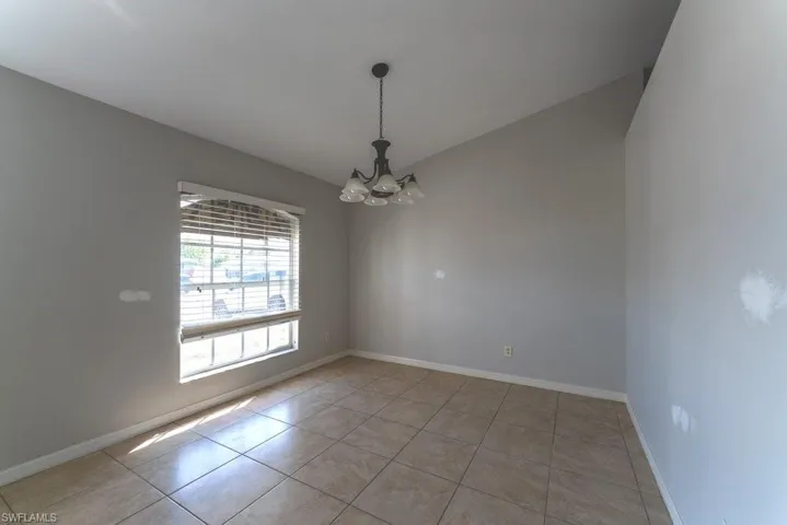 Unfurnished room featuring suspended lighting and light tile patterned floors