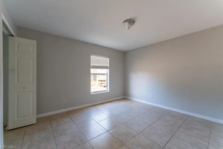 Empty room with baseboards and light tile patterned floors