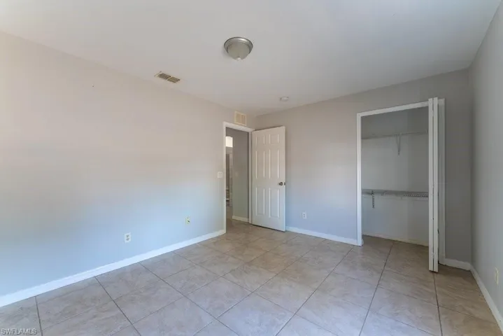 Unfurnished bedroom featuring a closet and light tile patterned floors