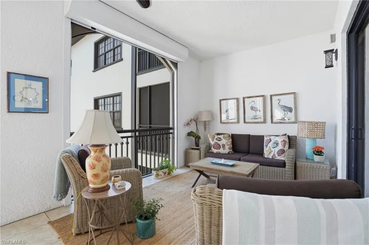 Living area with a textured wall, tile patterned flooring, and a textured ceiling