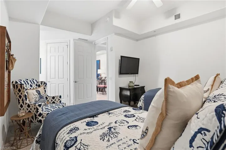 Bedroom featuring arched walkways and ceiling fan