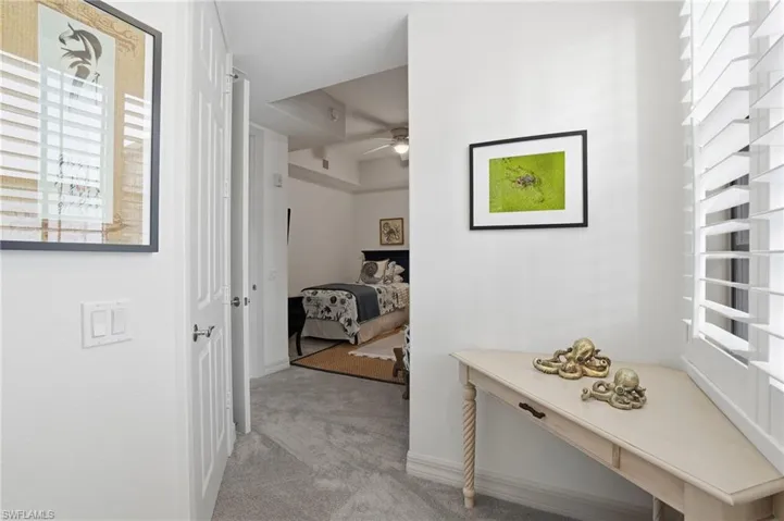 Corridor with healthy amount of natural light and light carpet