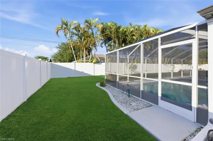 Fenced backyard with glass enclosure and a sunroom