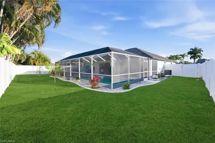 Back of house featuring a fenced backyard, a lanai, and a sunroom