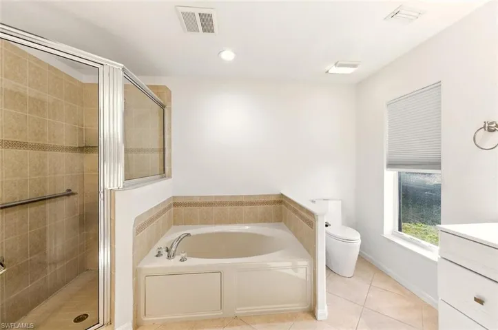 Full bathroom with vanity, a stall shower, a garden tub, recessed lighting, and light tile patterned floors