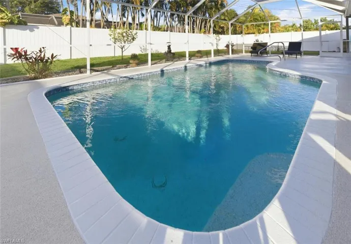 View of pool with glass enclosure, a patio, a fenced backyard, and a sunroom