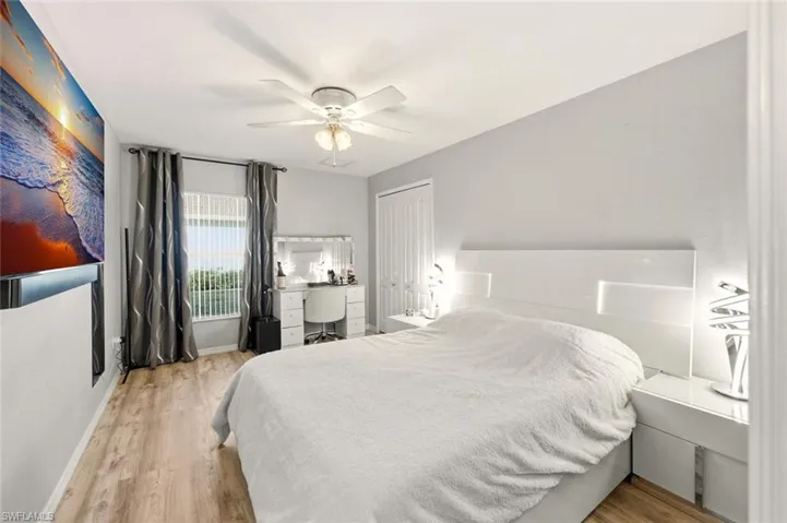 Bedroom featuring light wood-type flooring, a ceiling fan, and an office area