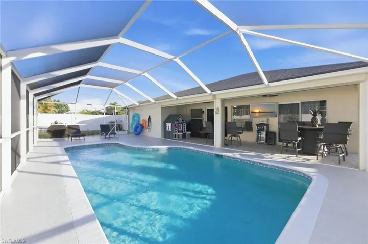 Swimming pool featuring a sunroom, a patio, and a lanai