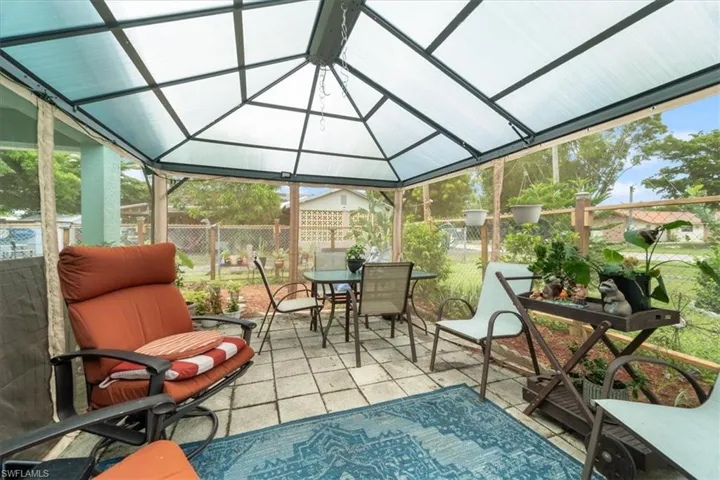 Sunroom / solarium featuring outdoor dining area, a patio area, lofted ceiling, and healthy amount of natural light